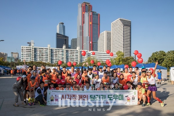 10월 12일 여의도한강공원에서 열린 시각장애인 마라톤 대회에서 참가자들과 봉사자들이 단체사진을 찍고 있다. [사진=OCI]