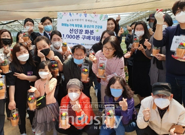 한국동서발전 화분 구매 및 전달식에 참석한 관계자들이 선인장을 들고 기념 촬영을 하고 있다. [사진=한국동서발전]