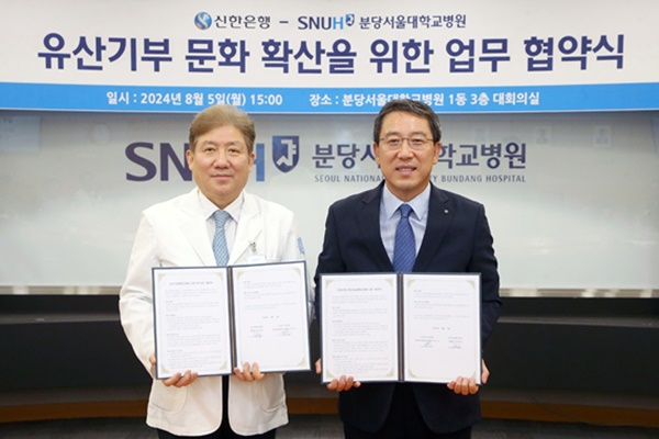 5일 진행된 ‘유산기부 문화 확산’을 위한 업무협약 체결식에서 분당서울대학교병원 송정한 병원장(왼쪽)과 신한은행 박의식 자산관리솔루션그룹장이 업무 협약서를 들어 보인 채 기념 촬영을 하고 있다. [사진=신한은행]