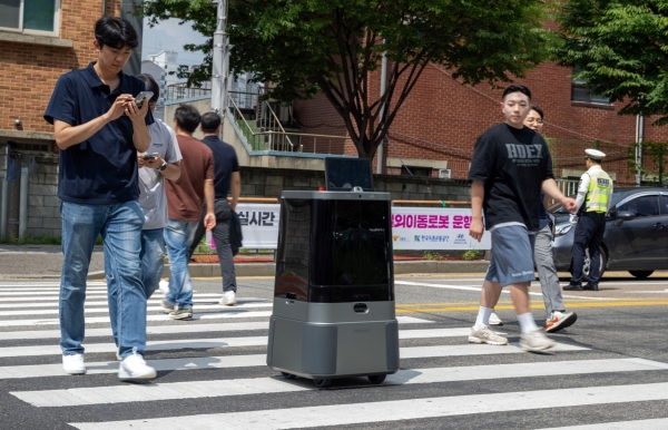 현대차·기아 로보틱스랩 자율주행 배송로봇이 경기도 의왕시 부곡파출소 앞에서 시민과 함께 횡단보도를 횡단하는 모습. [사진=현대차·기아]
