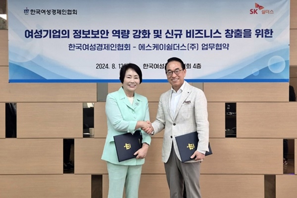 이정한 한국여성경제인협회 회장(왼쪽)과 홍원표 SK 쉴더스 대표가 13일 한국여성경제인협회 본사에서 열린 업무협약식에서 손을 맞잡으며 미소 짓고 있다. [사진=SK쉴더스]