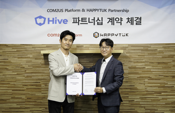 김종문 컴투스플랫폼 상무(왼쪽)와 양민영 해피툭 대표가 서비스 파트너십을 체결하고 함께 협약서를 들어 보이고 있다./사진=컴투스홀딩스