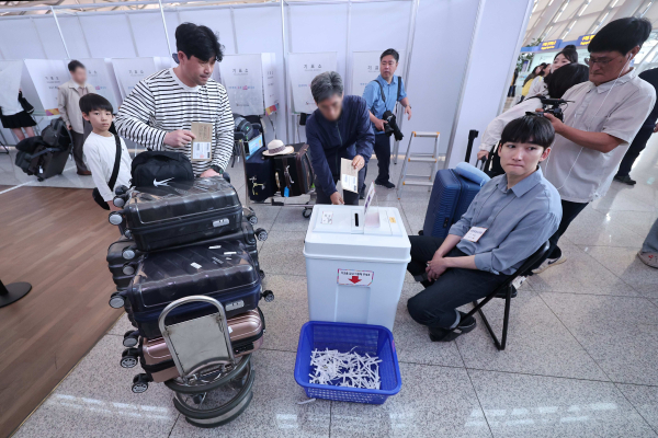 제21대 대통령선거 사전투표가 시작된 29일 오전 인천국제공항 제1여객터미널 출국장에 마련된 사전투표소에서 자녀와 동행한 한 유권자가 투표하고 있다. /사진=연합뉴스