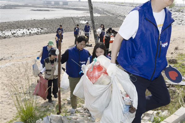지난달 30일 영종도 거잠포해변 일대에서 진행된 해변 정화활동에서 HMM 임직원과 해양경찰 등 봉사자들이 해변에 버려진 쓰레기를 줍고 있다./사진=HMM