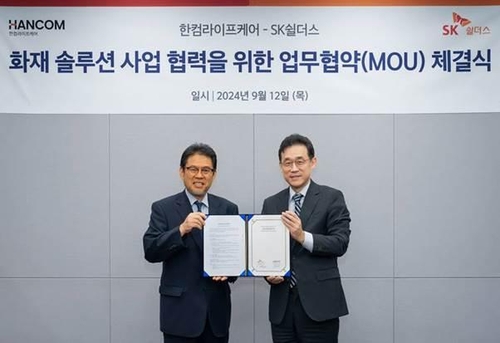 사김진중 SK쉴더스 융합보안사업부장(오른쪽)과 오병진 한컴라이프케어 대표가 협약서를 들어보이고 있다/ 사진 = SK쉴더스
