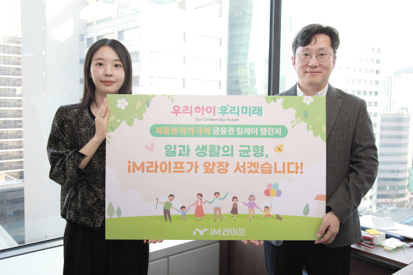 허원 iM라이프 운영혁신본부 전무(오른쪽)와 운영혁신본부 직원이 '저출생 위기 극복 챌린지'에 참여를 기념하기 위해 챌린지 플랜카드를 들고 있다./ 사진 = iM라이프